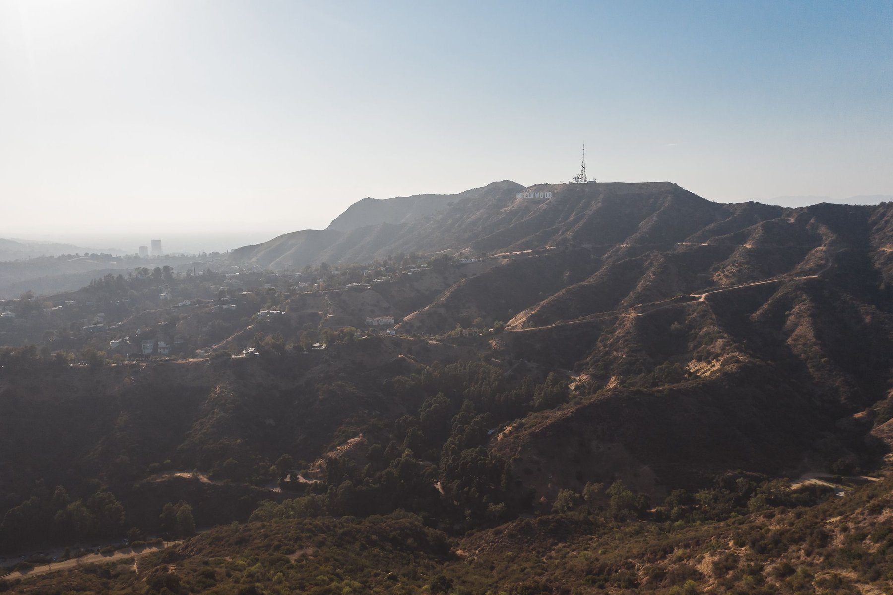 Black-and-white view of the Hollywood sign above the Hollywood Hills, with Los Angeles in the distance
